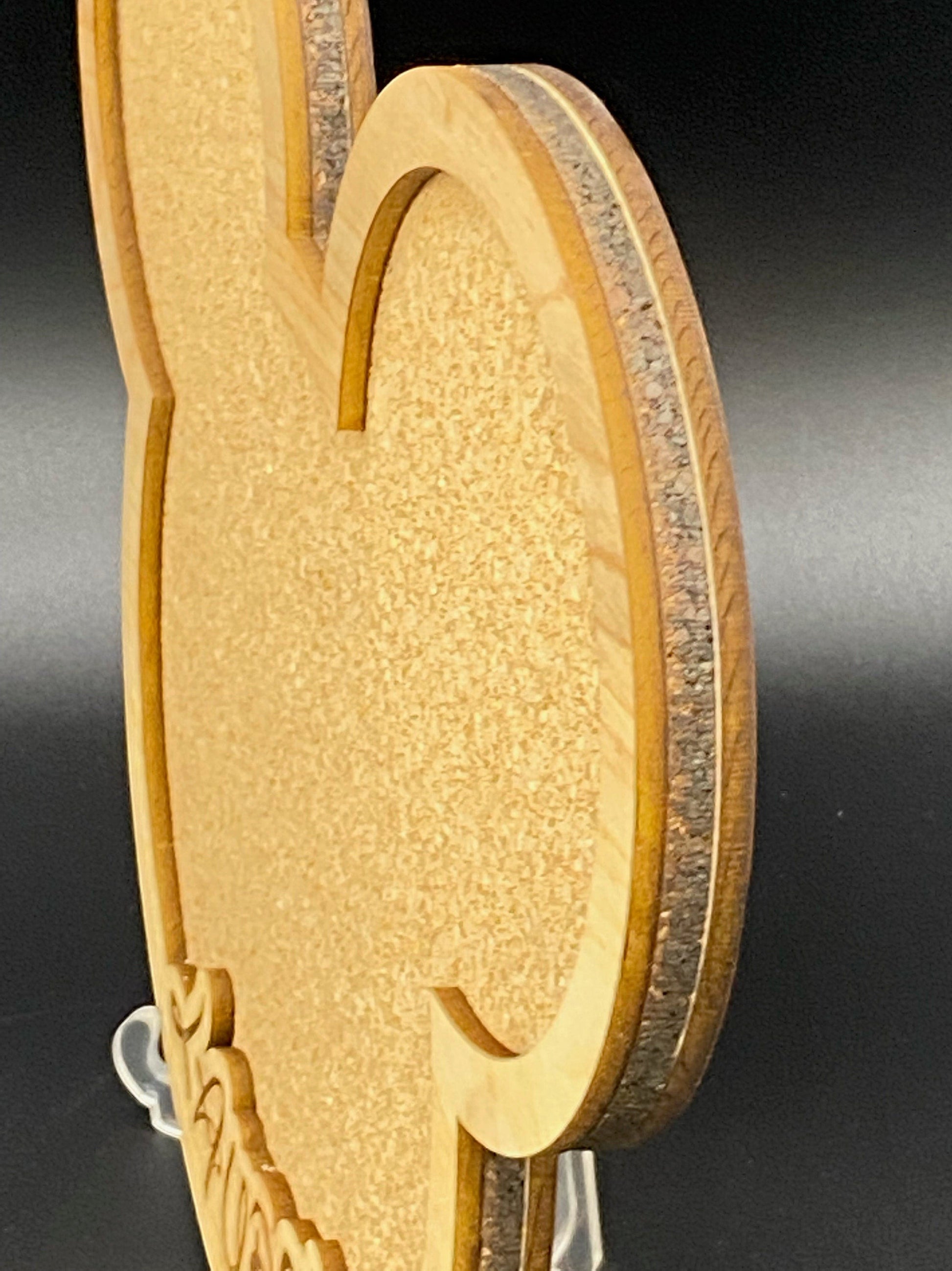 Freak of Laser character-shaped cork pin display board with wood frame and personalized engraving on a desk stand.
