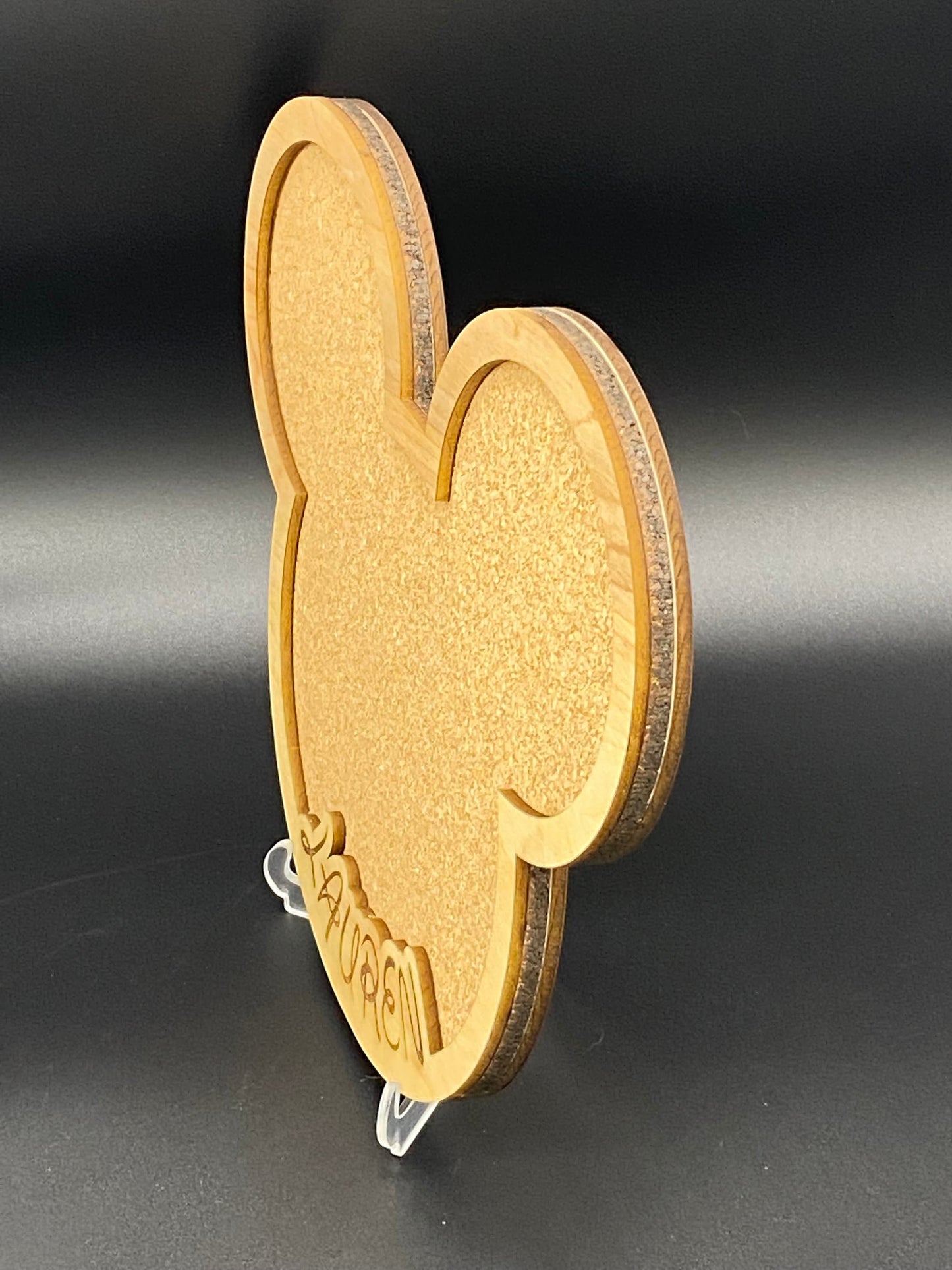 Freak of Laser personalized character-shaped cork pin display board with custom wood engraving on a clear stand.